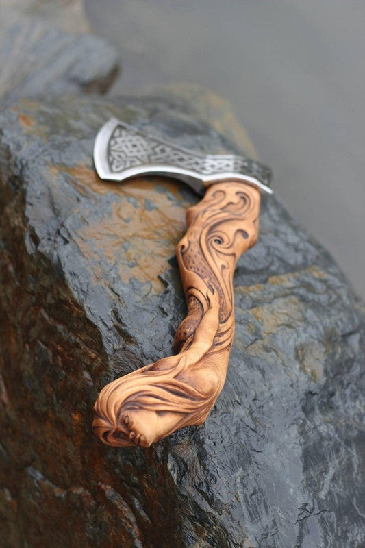 Hand-forged Viking axe and sword replicas displayed side by side